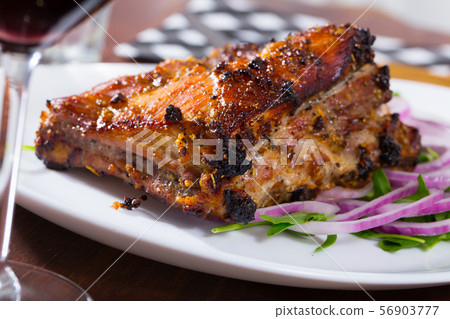 Grilled rack of pork with arugula and onion Grilled rack of pork with arugula and onion 56903777