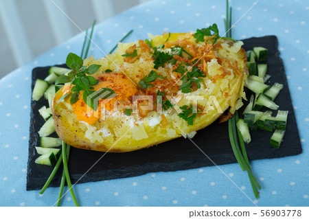 Baked potato with herbs, egg and cucumbers 56903778