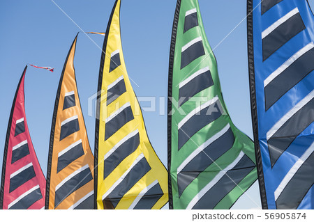 Five colorfull beach flags close-up on a blue sky Five colorfull beach flags close-up on a blue sky 56905874