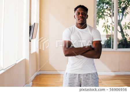 Serious ethnic sportsman standing with crossed arms Serious ethnic sportsman standing with crossed arms 56906936