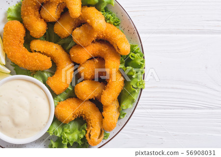 Shrimps in batter with sauce and lime 56908031