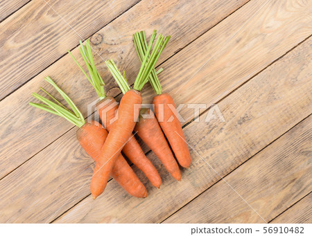 Fresh raw carrots on a wooden table. Fresh raw carrots on a wooden table. 56910482