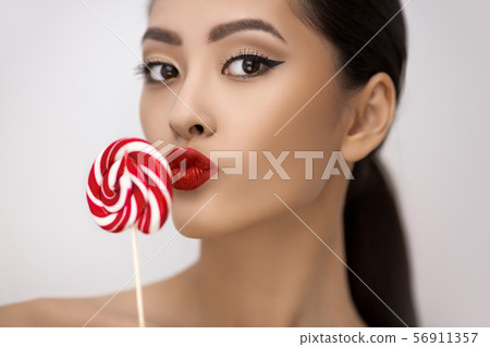 Fashion Portrait of Asian Woman with Lollipop in Studio Fashion Portrait of Asian Woman with Lollipop in Studio 56911357