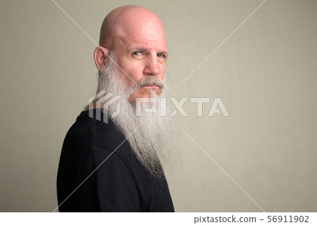 Profile view of mature bald man with long gray beard looking at camera 56911902