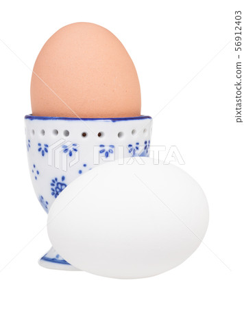 white egg and brown boiled egg in ceramic egg cup 56912403