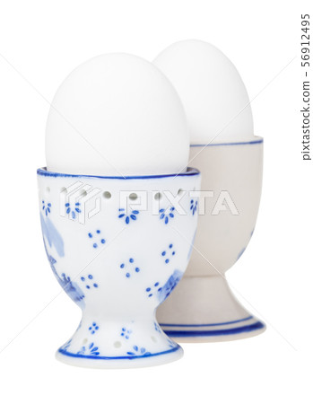 side view of pair of white boiled eggs in egg cups side view of pair of white boiled eggs in egg cups 56912495