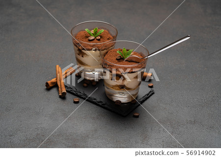 Portion of Classic tiramisu dessert in a glass cup on dark concrete background 56914902