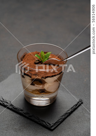 Portion of Classic tiramisu dessert in a glass cup on dark concrete background 56914906