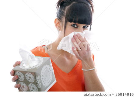 sick young girl blowing her nose on white 56914916