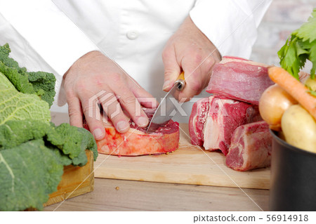 Chef cutting the meat on wooden board Chef cutting the meat on wooden board 56914918