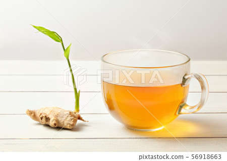 Freshly brewed cup of ginger tea (hot steam and 56918663