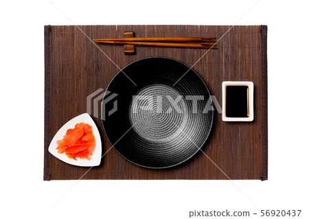 Empty round black plate with chopsticks for sushi, 56920437