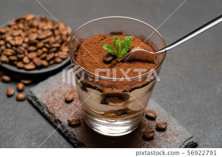 Portion of Classic tiramisu dessert in a glass cup on dark concrete background 56922791