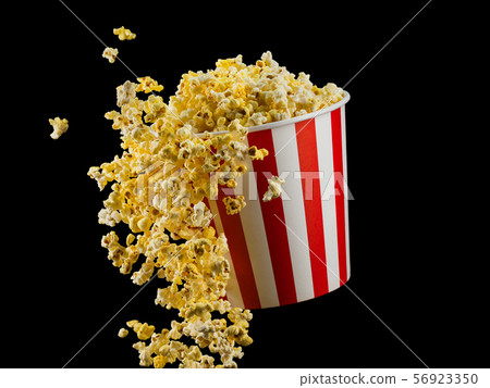 Flying popcorn from striped bucket isolated on black background Flying popcorn from striped bucket isolated on black background 56923350