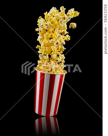 Paper striped bucket with popcorn isolated on black background 56923359