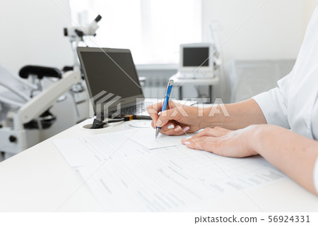 gynecologist doctor writes a recipe on a sheet of 56924331