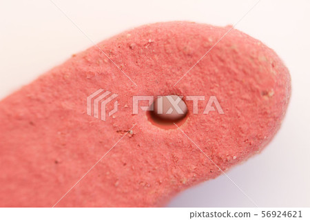 hole in a red clay heart covered with engobe. macro. 56924621