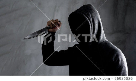 Dangerous hooded man standing in the dark and 56925826