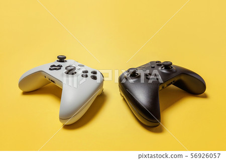 White and black two joystick on yellow background. White and black two joystick on yellow background. 56926057
