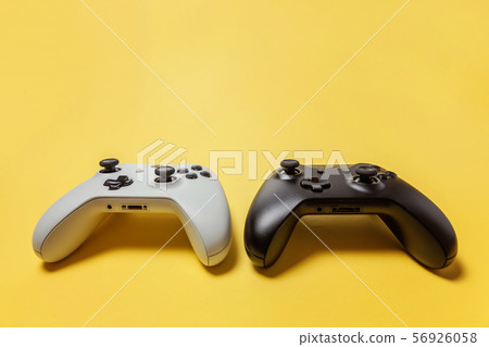 White and black two joystick on yellow background. White and black two joystick on yellow background. 56926058
