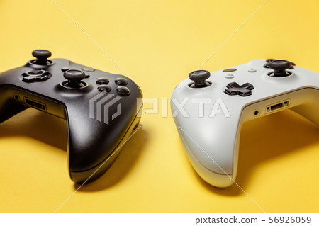 White and black two joystick on yellow background. White and black two joystick on yellow background. 56926059