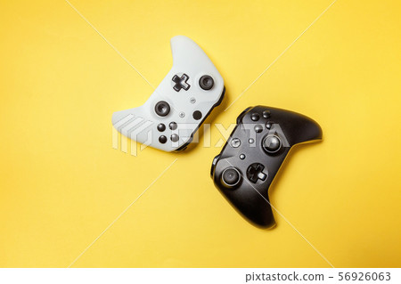 White and black two joystick on yellow background. White and black two joystick on yellow background. 56926063