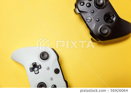 White and black two joystick on yellow background. White and black two joystick on yellow background. 56926064