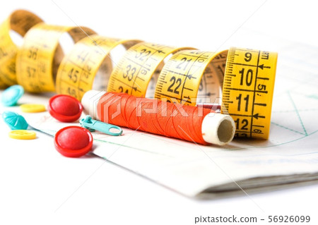 Sewing supplies on white sewing thread, scissors, pattern, centimeter, buttons Sewing supplies on white sewing thread, scissors, pattern, centimeter, buttons 56926099