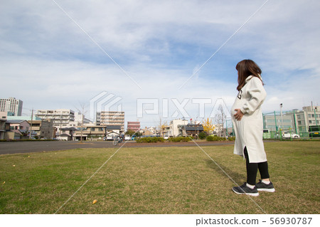 Pregnant woman looking up to the sky Pregnant woman looking up to the sky 56930787
