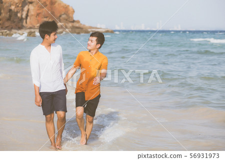 Homosexual young asian couple walking on beach Homosexual young asian couple walking on beach 56931973