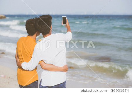 Back view gay young couple smiling taking a photo 56931974