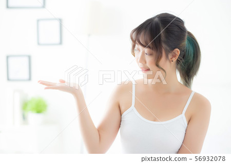 Beautiful young asian woman smiling and showing Beautiful young asian woman smiling and showing 56932078