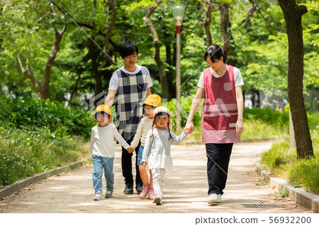 Childcare worker and kindergarten strolling in the park Childcare worker and kindergarten strolling in the park 56932200