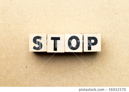 Letter block in word stop on wood background Letter block in word stop on wood background 56932570