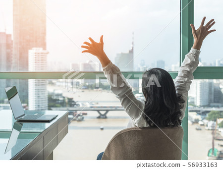 Work-life balance, work done and success celebration concept with happy woman take it easy casually resting in luxury business hotel or at home office workplace with computer pc laptop on desk 56933163