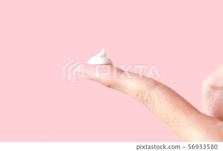 White cosmetic cream on finger tip isolated on pink background 56933580