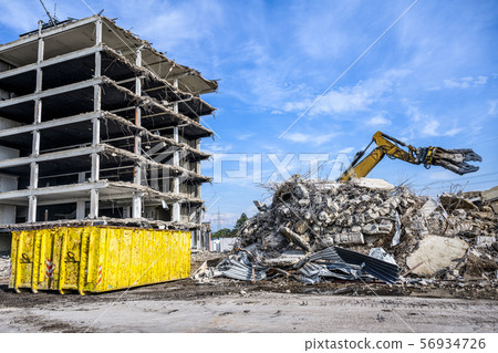 Building House Demolition site Excavator with hydraulic crasher machine and yellow container 56934726
