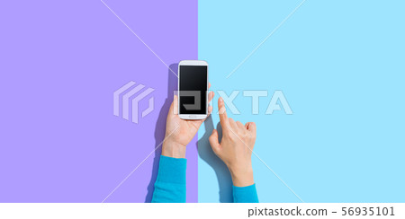 Person using a white smartphone Person using a white smartphone 56935101