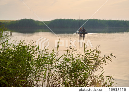 An elderly people fishing in boat around forest An elderly people fishing in boat around forest 56938356