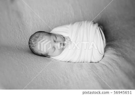 newborn baby sleeps wrapped in a blanket. concept of childhood, healthcare, IVF. Black and white photo newborn baby sleeps wrapped in a blanket. concept of childhood, healthcare, IVF. Black and white photo 56945651