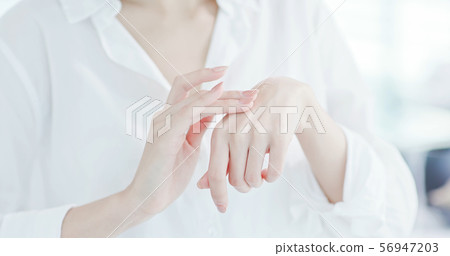 woman applying lotion on hand woman applying lotion on hand 56947203