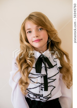 Cute girl with long curly hair in school fashion clothes. School fashion in vintage elite style. Cute girl with long curly hair in school fashion clothes. School fashion in vintage elite style. 56949760