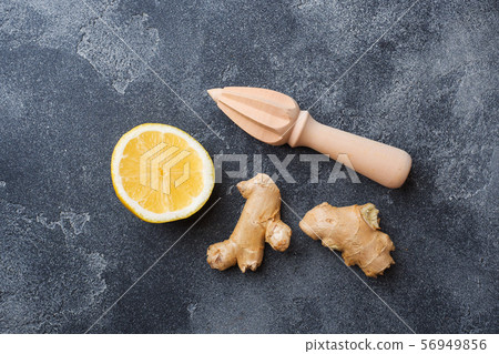 Lemon and ginger root on dark grey background with copy space. Ingredients for a tonic vitamin drink. Lemon and ginger root on dark grey background with copy space. Ingredients for a tonic vitamin drink. 56949856