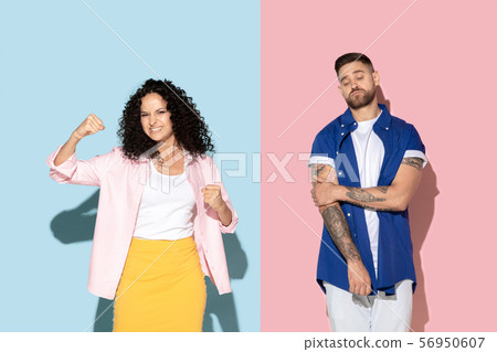 Young emotional man and woman on pink and blue background Young emotional man and woman on pink and blue background 56950607
