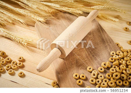crunchy breakfast on a wooden table with ears of rye and rolling pin 56951234