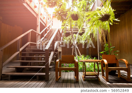 Wooden stair with arm chair and plant in terrace. Wooden stair with arm chair and plant in terrace. 56952849