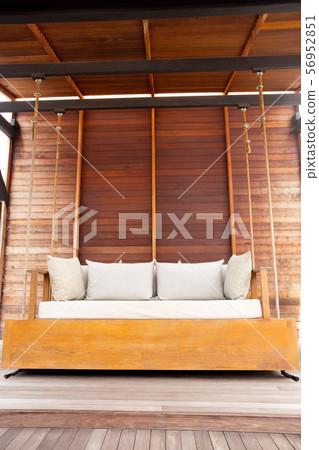 Outdoor porch big swing wooden chair with cushion on the terrace with wooden floor. Outdoor porch big swing wooden chair with cushion on the terrace with wooden floor. 56952851