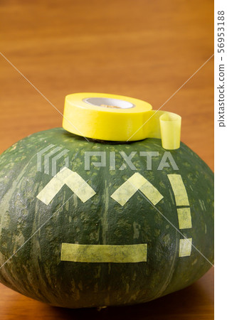 A pumpkin with a masking tape painted in the style of a jack-o-lantern for Halloween. 56953188