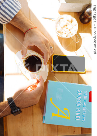 Top view of a coffee cup in male hands 56955062