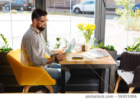 Delighted cheerful man looking into the book 56955066